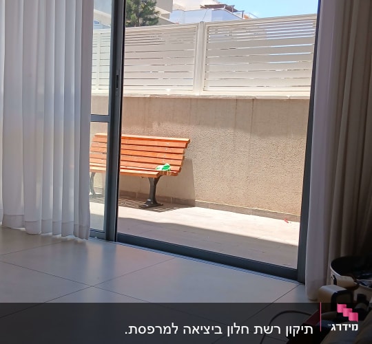 חלון זכוכית עם וילון ונוף חיצוני
